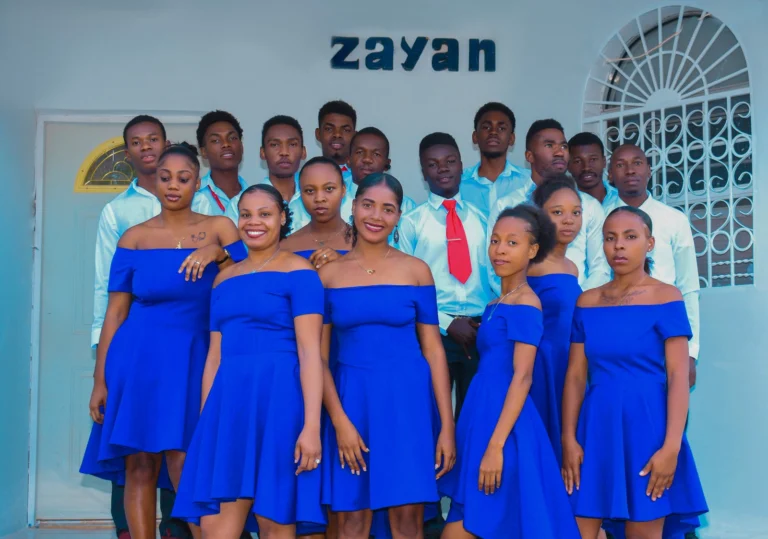 Groupe en tenues bleues et blanches devant le mur au nom de Zayan